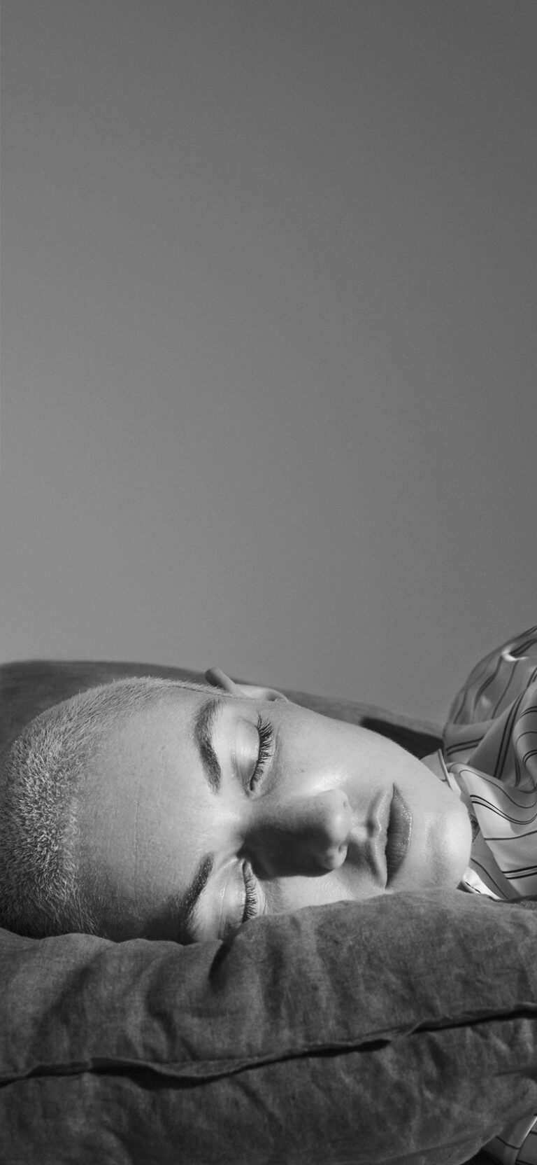 Femme qui dort dans son lit avec des bouchons d'oreilles Happy Ears